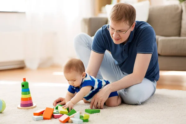 Pai feliz com bebê filho brincando de brinquedos em casa — Fotografia de Stock