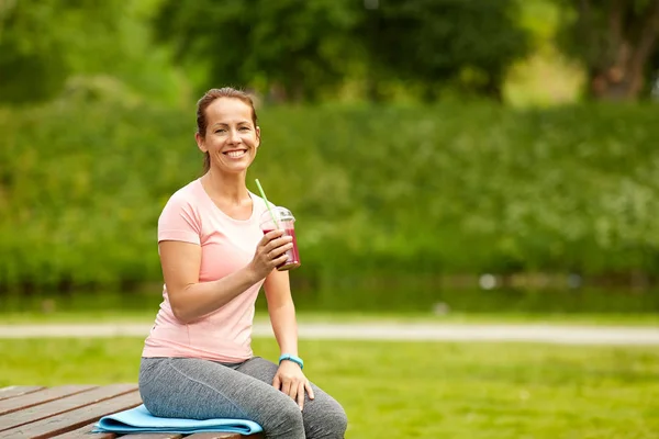 公園で運動した後女性飲むスムージー — ストック写真
