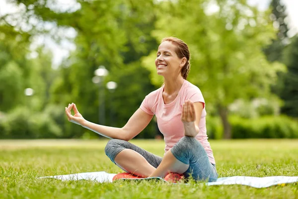 Gelukkige vrouw mediteren in zomer park — Stockfoto