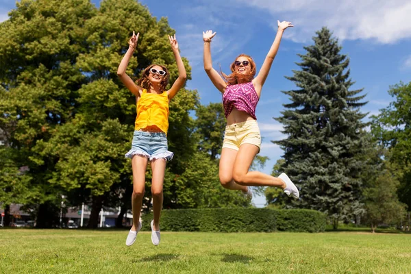 Счастливые девочки-подростки прыгают в летнем парке — стоковое фото
