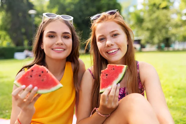 Девушки-подростки едят арбуз на пикнике в парке — стоковое фото