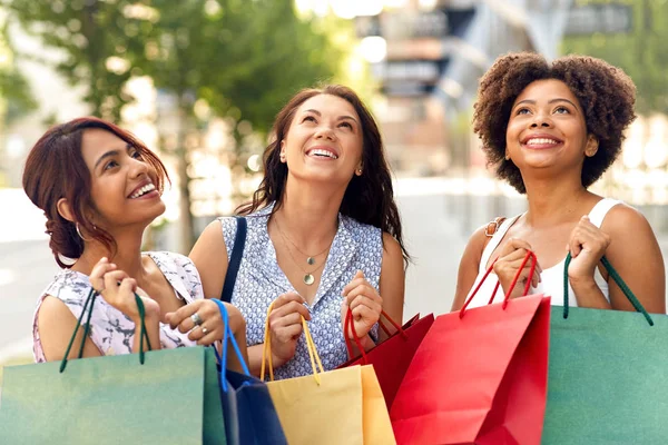 Mujeres felices con bolsas de compras en la calle de la ciudad —  Fotos de Stock