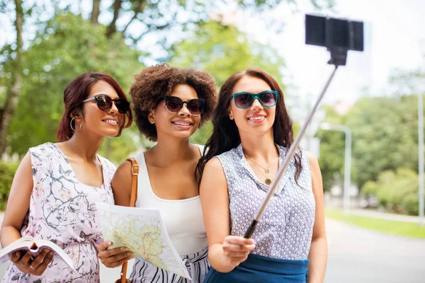 Vrouwen met city guide en kaart nemen selfie — Stockfoto