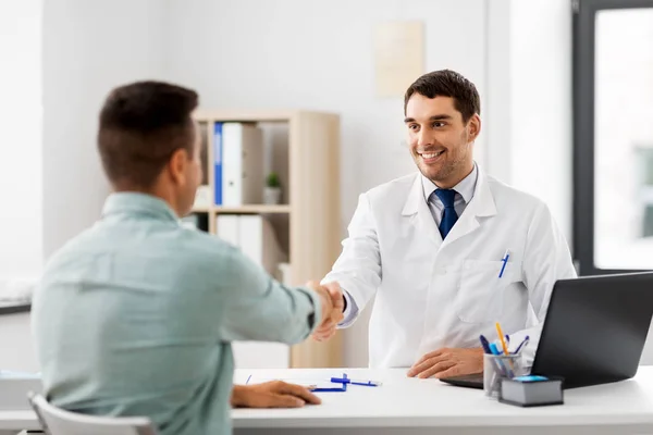 Doctor and male patient shaking hands at hospital — Stock Photo, Image