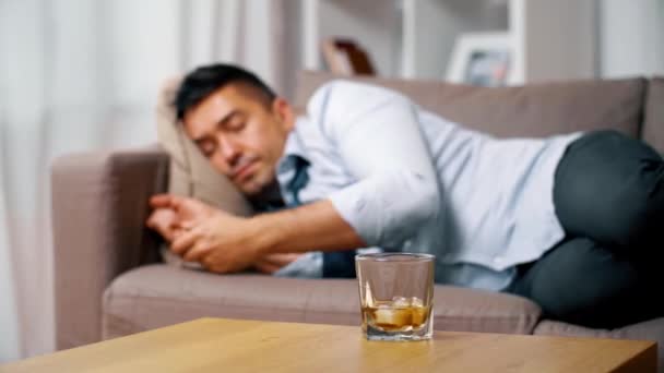 Alcoholic lying on sofa and drinking whiskey — Stock Video