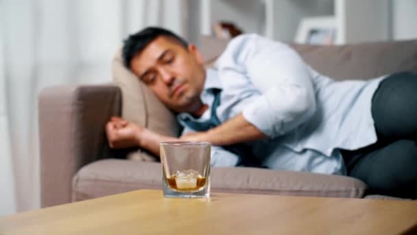 Alcoholic lying on sofa and drinking whiskey — Stock Video