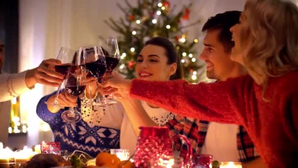 Glada vänner dricka rödvin på julbord — Stockvideo