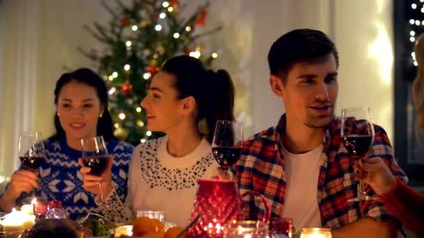 Amigos felices bebiendo vino tinto en Navidad — Vídeos de Stock