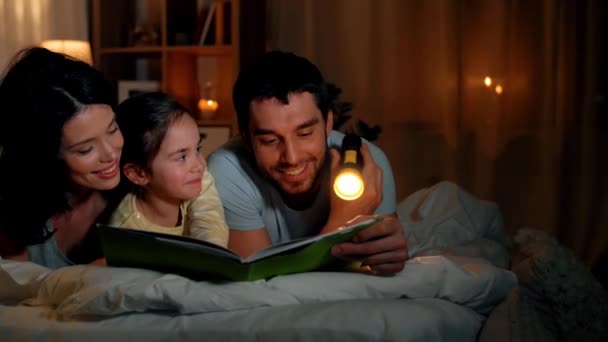 Libro de lectura familiar feliz en la cama por la noche en casa — Vídeos de Stock