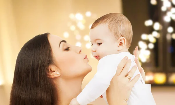 Mamma kysser barnet över julbelysning — Stockfoto