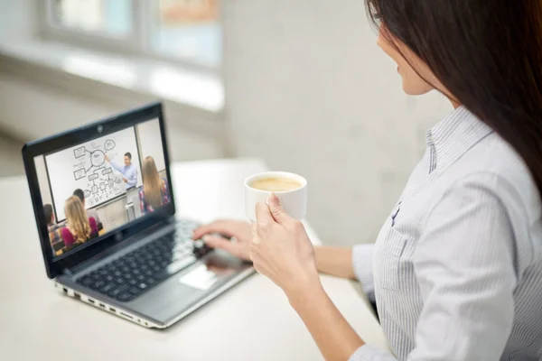 Kvinna med kaffe titta på webinar på laptop — Stockfoto