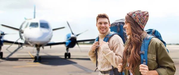 Casal de turistas com mochilas sobre avião — Fotografia de Stock