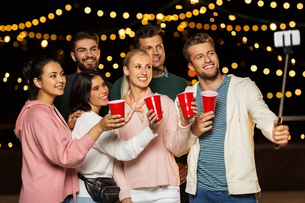 Amigos com bebidas tomando selfie na festa no telhado — Fotografia de Stock