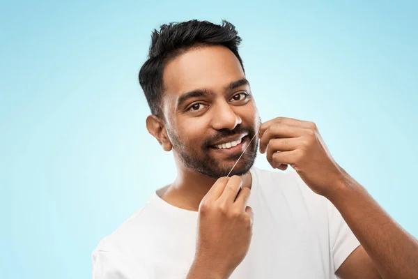 Uomo indiano con denti di pulizia filo interdentale — Foto Stock