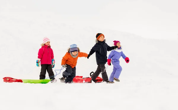 Happy little kids with sleds in winter — Stock Photo, Image