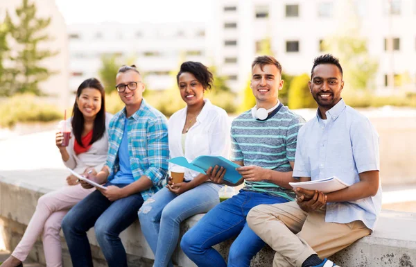 Estudantes com caderno e bebidas takeaway — Fotografia de Stock