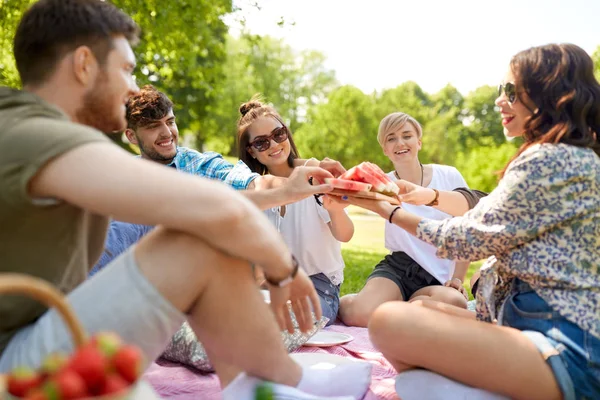 Happy vrienden delen van watermeloen op zomerpicknick — Stockfoto