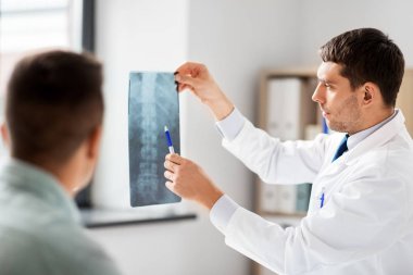 doctor showing x-ray to patient at hospital clipart