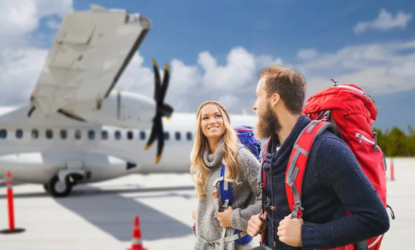 Casal de turistas com mochilas sobre avião — Fotografia de Stock