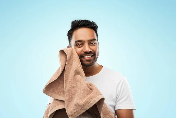 Uomo indiano sorridente con asciugamano su sfondo blu — Foto Stock