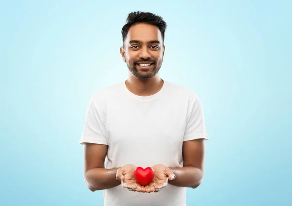 Uomo indiano sorridente con il cuore rosso sopra grigio — Foto Stock