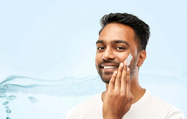 Felice uomo indiano applicando crema per il viso — Foto Stock