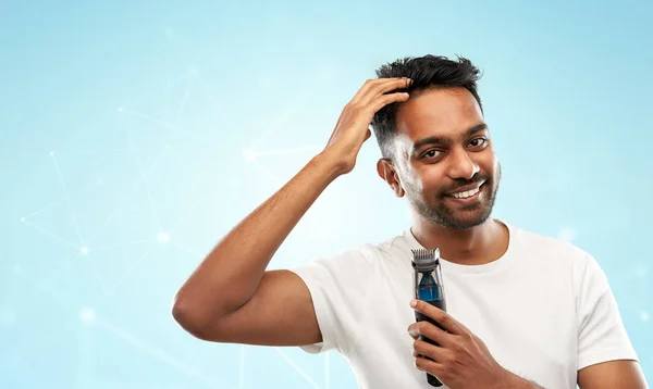 Lächelnder indischer Mann mit Trimmer, der sein Haar berührt — Stockfoto