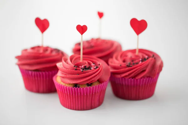 Close up of cupcakes with heart cocktail sticks — Stock Photo, Image