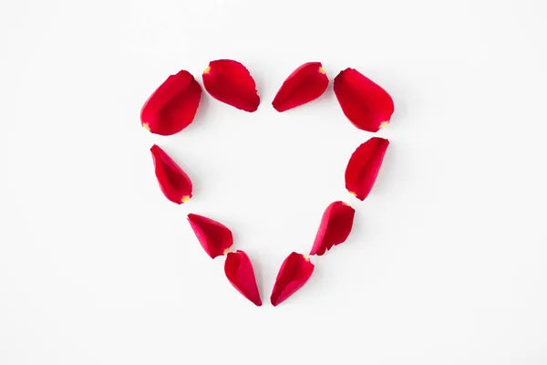 Kırmızı gül yaprakları kalp şekli yapılır — Stok fotoğraf