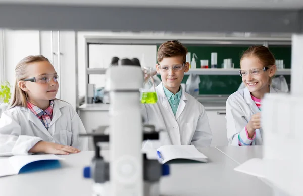 Niños con tubos de ensayo que estudian química en la escuela — Foto de Stock