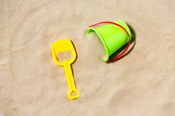 Wiadro zabawek i łopata na plaży piasek — Zdjęcie stockowe