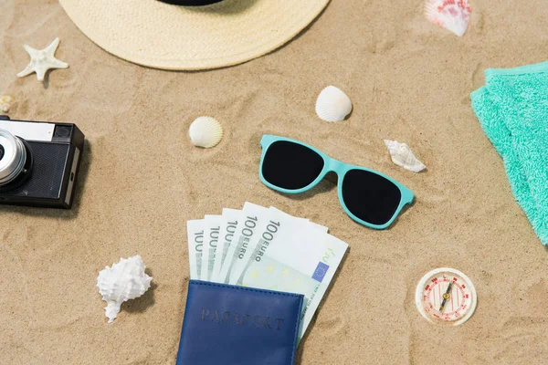 钱在护照, 阴影和帽子在沙滩上的沙子 — 图库照片