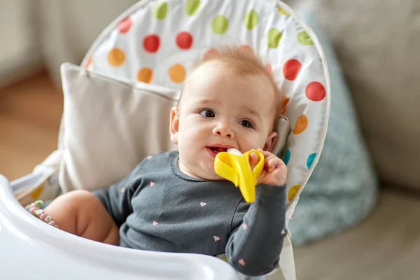 Meisje van de baby met Bijtring speelgoed in kinderstoel thuis — Stockfoto