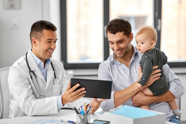 Pai com bebê e médico com tablet na clínica — Fotografia de Stock