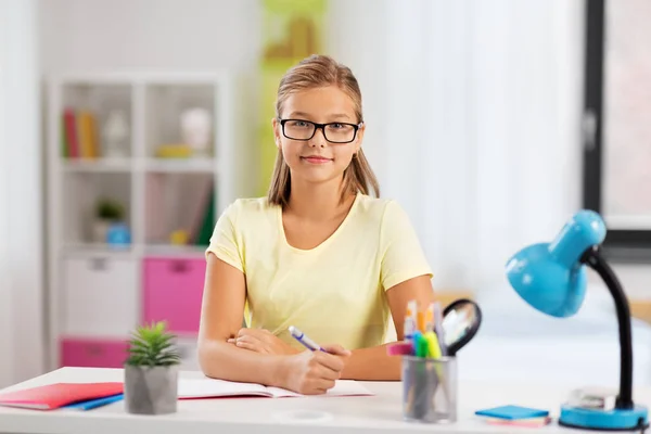 Chica estudiante feliz haciendo la tarea en casa —  Fotos de Stock