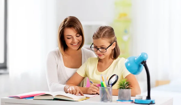 Mãe e filha fazendo lição de casa juntos — Fotografia de Stock