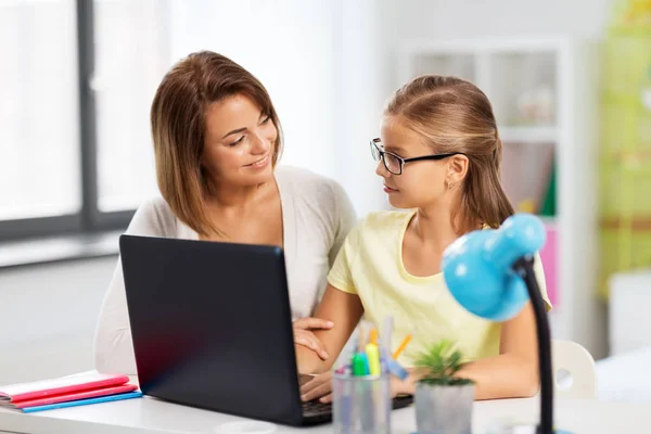 Мать и дочь с ноутбуком делает домашнее задание — стоковое фото