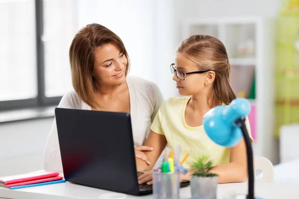 Mãe e filha com laptop fazendo lição de casa — Fotografia de Stock