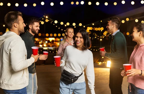 Amici con bevande che ballano alla festa sul tetto — Foto Stock