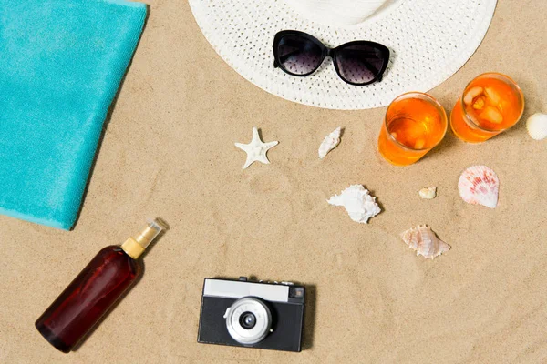 Drycker, hatt, kamera och solglasögon på stranden sand — Stockfoto