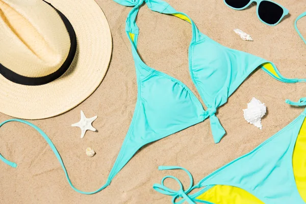 Bikini, cappello, fotocamera e occhiali da sole sulla sabbia della spiaggia — Foto Stock