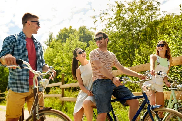 Amigos felices montando bicicletas de engranaje fijo en verano —  Fotos de Stock