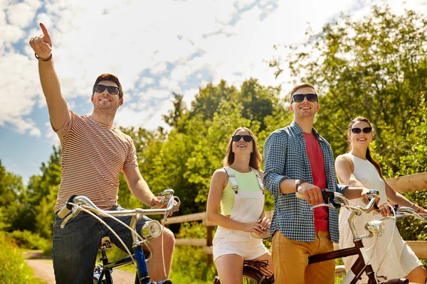 Amici felici a cavallo di biciclette a scatto fisso in estate — Foto Stock