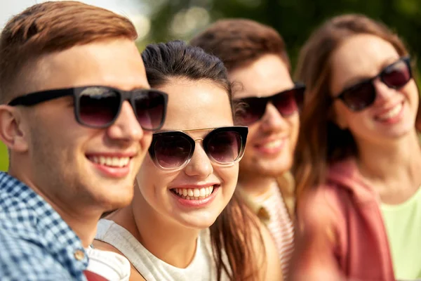 Счастливые друзья-подростки в солнцезащитных очках на улице — стоковое фото