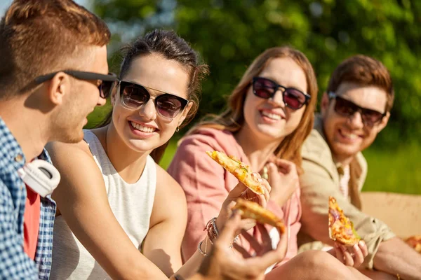Amici che mangiano pizza al picnic nel parco estivo — Foto Stock