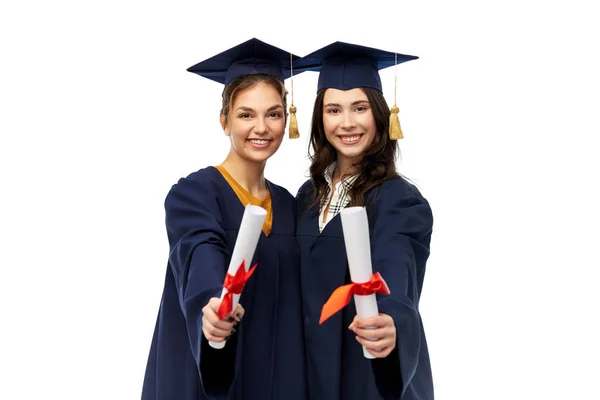 Femmes diplômées dans les panneaux de mortier avec diplômes — Photo