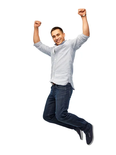 Šťastný mladý muž skákání přes bílé pozadí — Stock fotografie