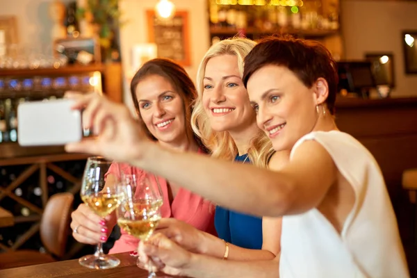 Женщины делают селфи на смартфоне в винном баре — стоковое фото