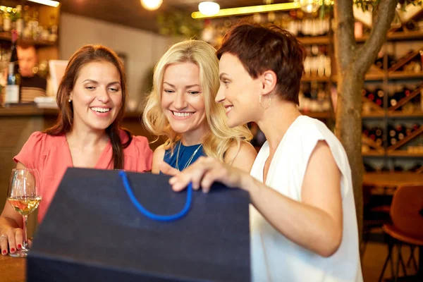 Mulheres com sacos de compras no bar ou restaurante de vinhos — Fotografia de Stock