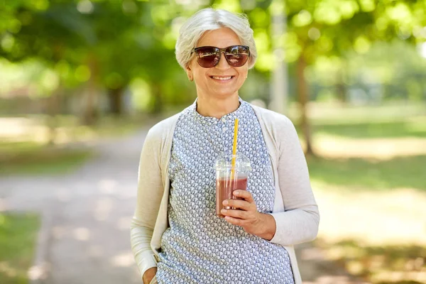 Старша жінка п'є злітно-посадкова смуга в парку — стокове фото